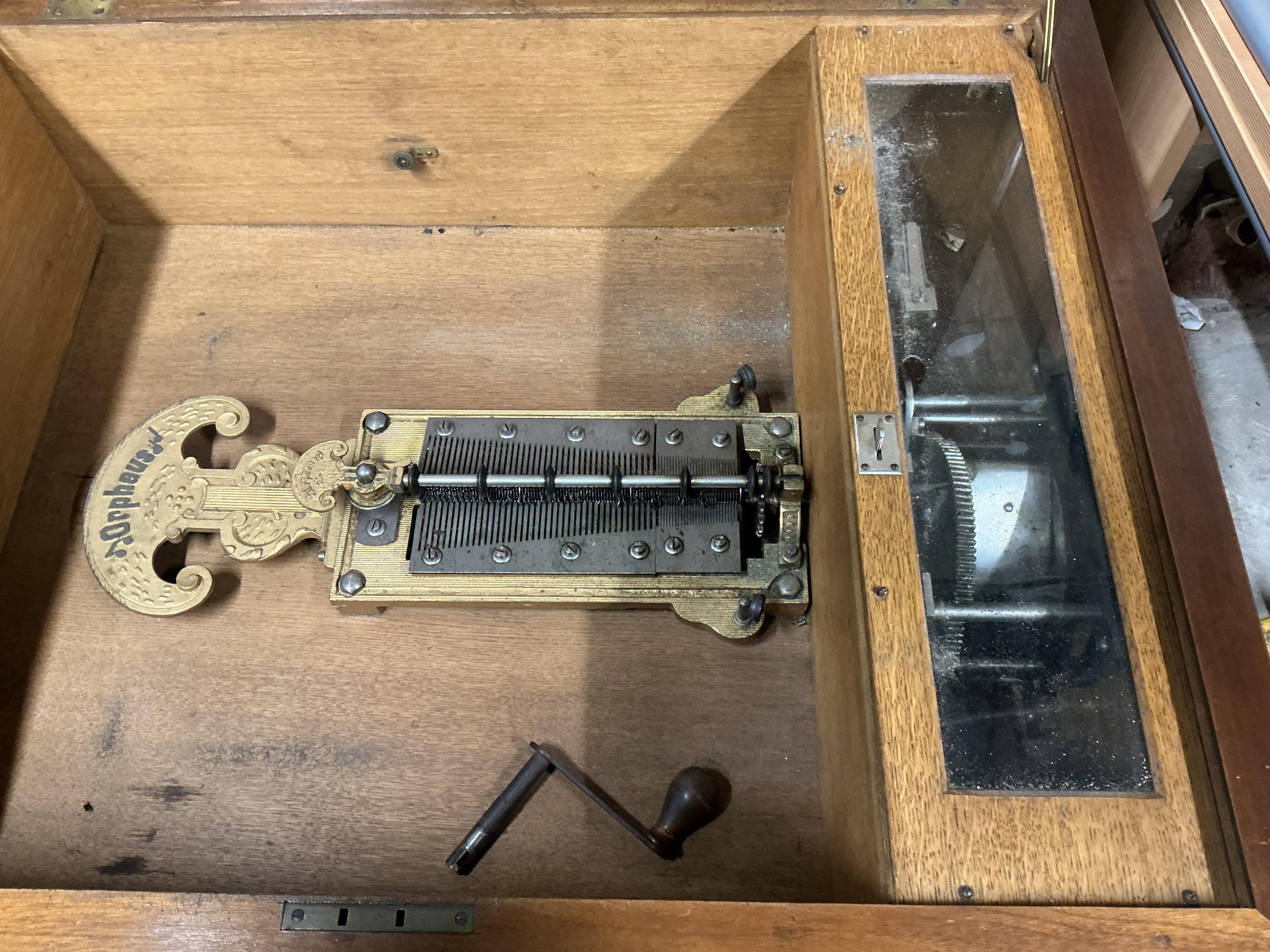 A substantial early 20th century inlaid walnut cased tabletop Orpheus polyphon on a floor standing base containing a compartment for storing the discs, together with thirty-seven 57.5cm diameter discs, and a winding hand